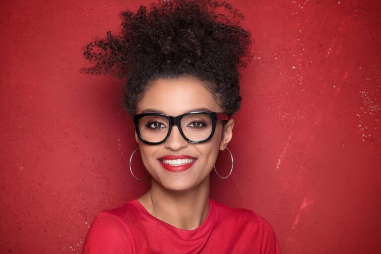smiling beautiful african american young woman with afro wearing eyeglasses