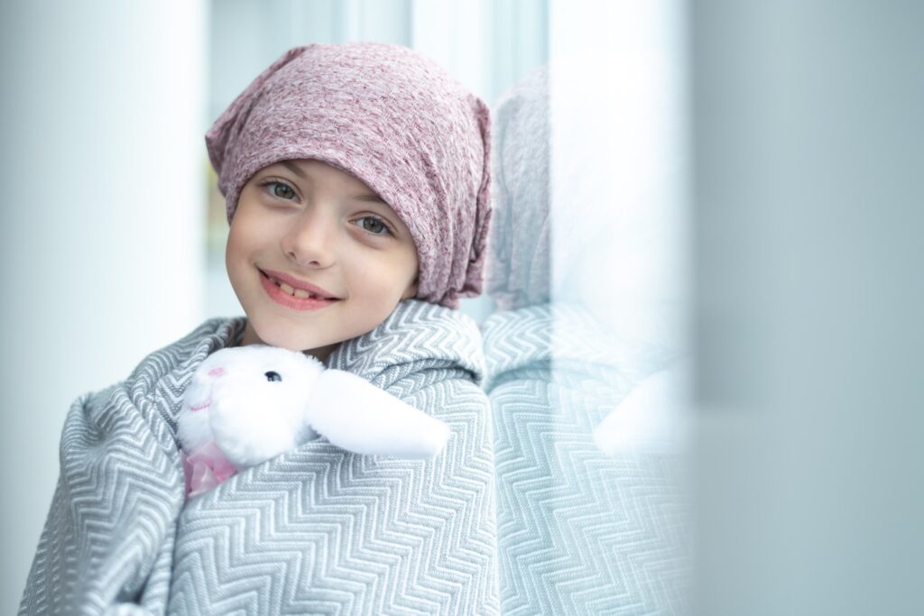 girl with cancer holding a stuffed toy